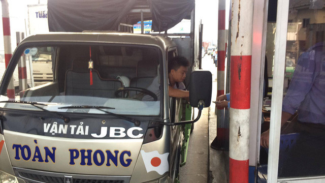 ... sau đó anh này tiếp tục đi vào trạm, tắt máy xe và đếm từng tờ tiền lẻ để mua vé.