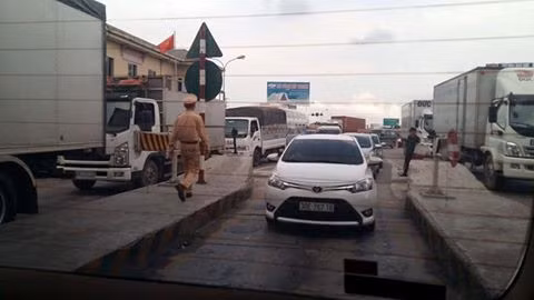 Lực lượng cảnh sát giao thông đứng ở trạm thu phí số 1, quốc lộ 5 hỗ trợ đề phòng ùn tắc giao thông. Ảnh:Mạnh Quân. Quoc lo 5 un tac vi tai xe dung tien le tra phi BOT hinh anh 1