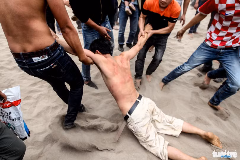 Thanh niên này bị ngất xỉu đang được đồng đội kéo ra khỏi đám đông hỗn loạn - Ảnh: Nguyễn Khánh