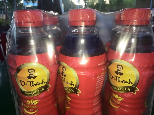 Chai mang nhãn hiệu Dr Thanh có màu xanh lạ ở giữa khi chùm sản phẩm đang nguyên đai, nguyên kiện.