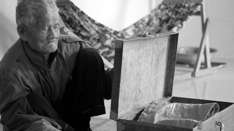 Ông Nhỏ bên chiếc rương cũ đã hoen gỉ, kỷ vật còn sót lại của liệt sỹ Túy. Chiếc rương này nay được ông dùng để đựng áo quan, dành cho tang lễ của chính mình.