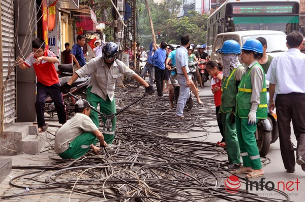 Các công nhân cắt "rác trời" dưới lòng đường.