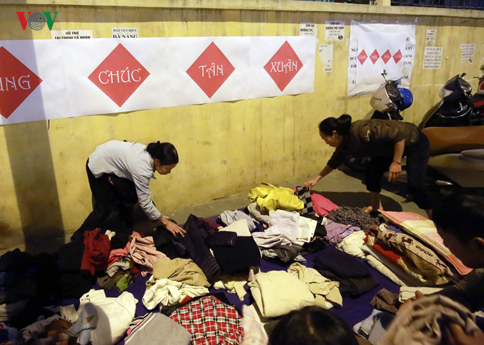 Những bộ quần áo được giặt sạch sẽ, gấp gọn ghẽ phía sau quầy bánh chưng để người lao động nghèo lựa chọn.