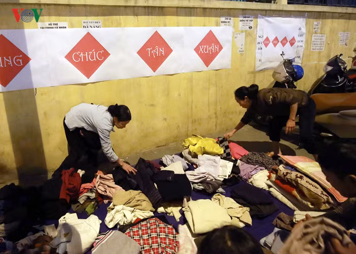 Những bộ quần áo được giặt sạch sẽ, gấp gọn ghẽ phía sau quầy bánh chưng để người lao động nghèo lựa chọn.