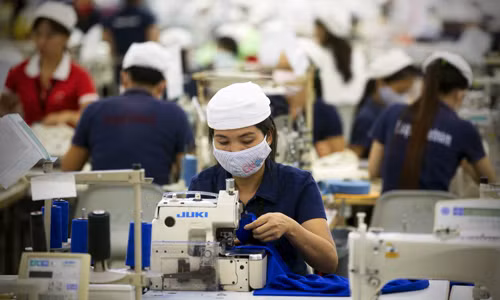 Quy định mới trong đóng bảo hiểm xã hội sẽ gây áp lực lên các doanh nghiệp sử dụng nhiều lao động. Ảnh: Bloomberg