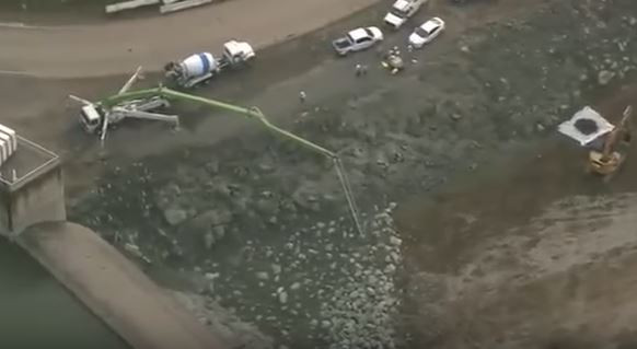 Khu vực chân đập đang được gia cố bằng đá hộc và bê tông.