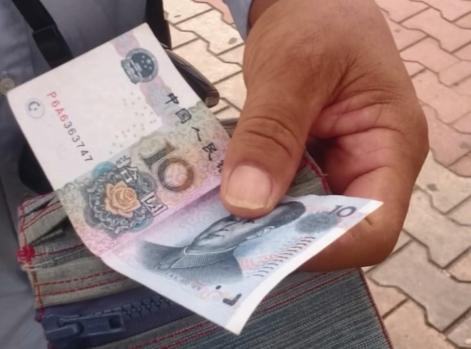 Nhiều du khách Trung Quốc vẫn dùng tiền Nhân dân tệ ra thanh toán khi mua hàng. Ảnh:H. Long.