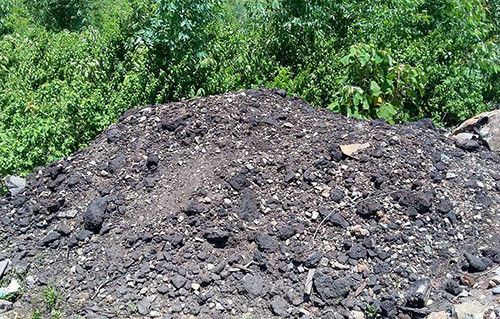 Khoảng 10 tấn đất đá màu đen nghi chất thải được xác định là vật liệu xây dựng. Ảnh:Đ.H