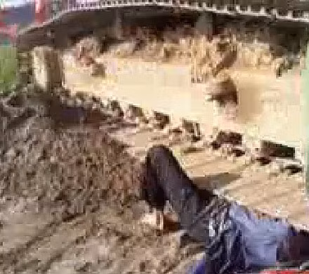 Bà Châm được cho là bị máy xúc chèn qua người và may mắn không tử vong. Tuy nhiên lãnh đạo tỉnh Hải Dương khẳng định bà Châm chỉ va chạm với máy xúc. (Hình ảnh cắt từ video clip do người dân cung cấp)