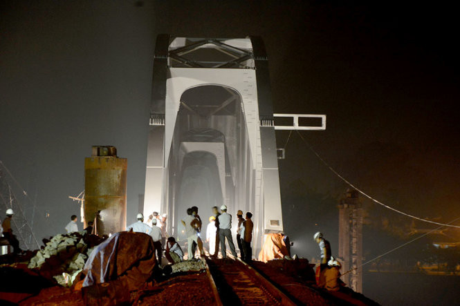 Các công nhân nỗ lực hoàn thành công đoạn cuối trong đêm 24 và rạng sáng 25-6 để chuẩn bị thông cầu Ghềnh - Ảnh: ĐỨC TRONG