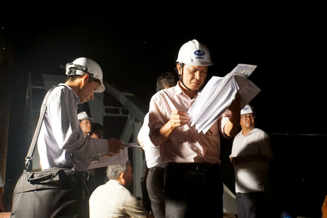 Kỹ sư dùng máy kiểm tra các vị trí, độ cân bằng trên đường tàu nằm trong lòng cầu Ghềnh mới - Ảnh: H.M