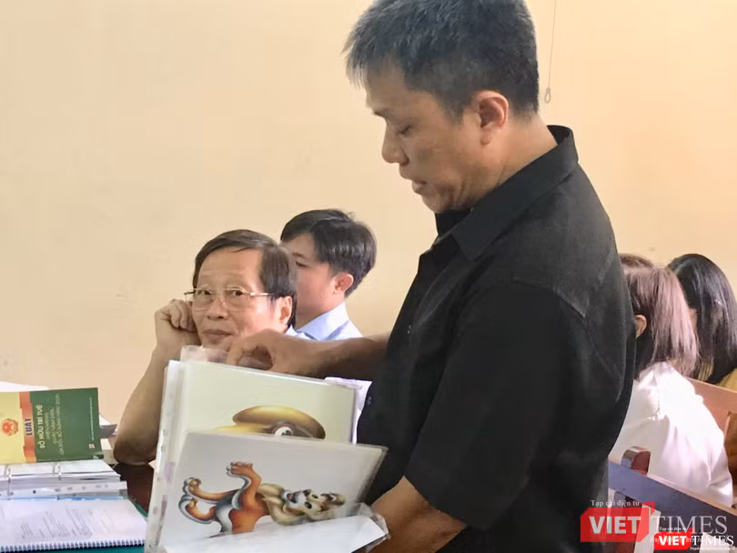 Họa sĩ Lê Linh trình bày trước HĐXX, ông Nguyễn Vân Nam (đại diện Công ty Phan Thị) bên trái ảnh Họa sĩ Lê Linh trình bày trước HĐXX, ông Nguyễn Vân Nam (đại diện Công ty Phan Thị) bên trái ảnh