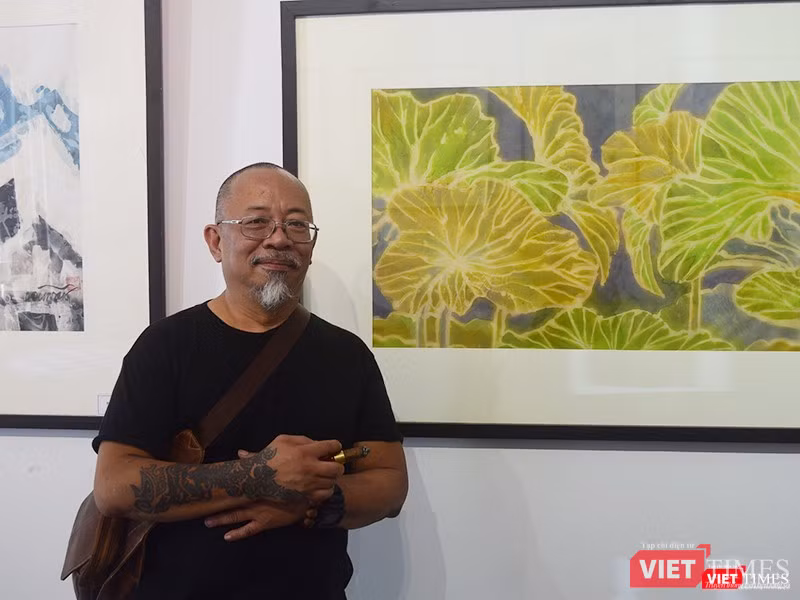 Họa sĩ Bùi Việt Dũng bên các tác phẩm đang trưng bày tại "Tứ diện cũ"