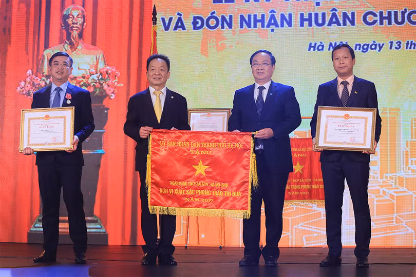 Phó Chủ tịch UBND TP Hà Nội Nguyễn Thế Hùng trao cờ Thi đua và bằng khen của Chủ tịch UBND TP cho các tập thể, cá nhân thuộc SHB vì đã đạt thành tích xuất sắc trong phong trào thi đua, góp phần hoàn thành nhiệm vụ Khối doanh nghiệp năm 2017.