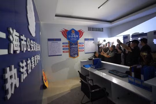 Các phóng viên quốc tế quay phim, chụp ảnh trụ sở đồn cảnh sát Thượng Hải giả được băn nhóm lừa đảo dựng lên để làm bối cảnh lừa đảo người dân Trung Quốc. Ảnh: Reuters.