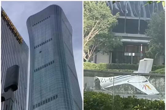 Tòa nhà CITIC Tower bị chiếc máy bay đâm va và phần đuôi chiếc máy bay rơi xuống. Ảnh: HK01.
