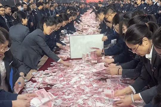 Các nhân viên được thưởng đua nhau đếm tiền để mang về. Ảnh: Singtao.