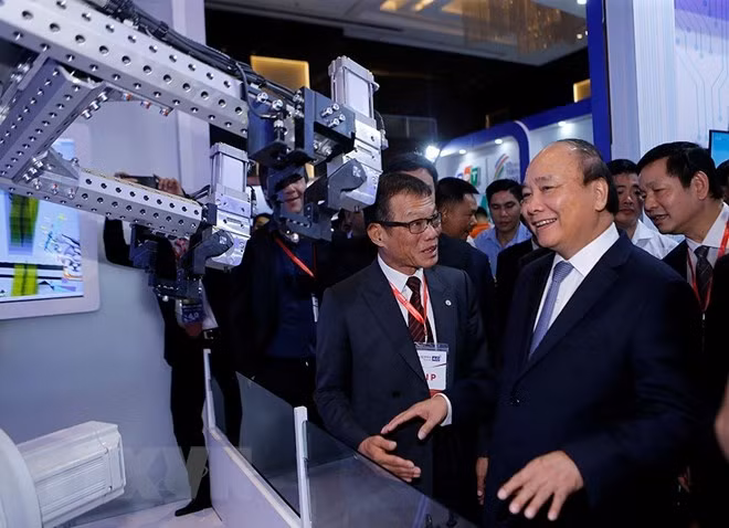Ông Võ Quang Huệ giới thiệu với Thủ tướng về robot đang được sử dụng trong nhà máy lắp ráp và sản xuất xe hơi mang thương hiệu VinFast.