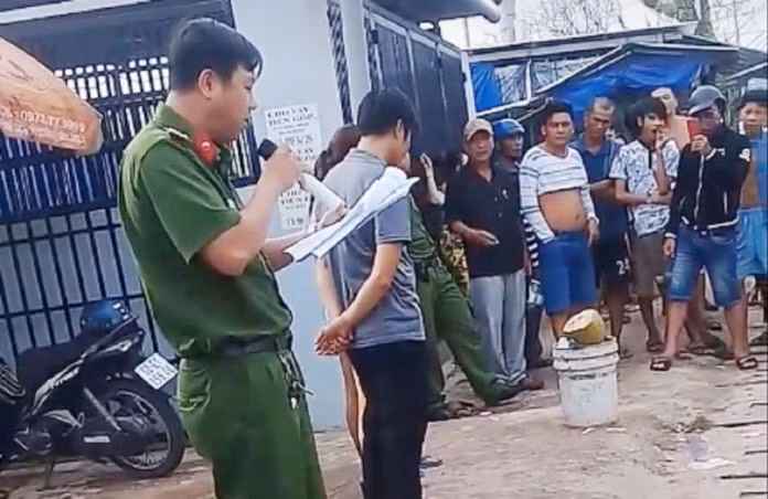 Trong đoạn clip, công an cầm micro đọc rõ to hành vi mua bán dâm và yêu cầu những người bị bêu danh bước lên cho người đi đường nhìn rõ mặt. Ảnh cắt từ video.