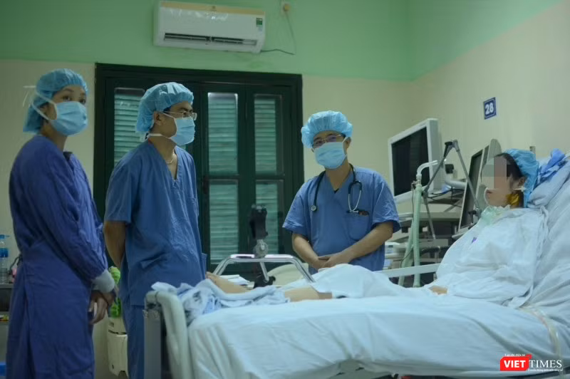Bác sĩ giúp chị H. tập phục hồi chức năng tại giường (Ảnh: Quang Hùng)