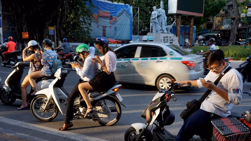 Nhiều người vừa đi xe máy vừa dán mắt vào điện thoại để chơi game Pokemon Go, tiềm ẩn nguy cơ gây tai nạn giao thông.