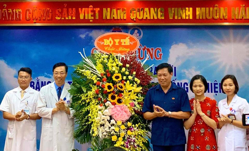 Thứ trưởng Bộ Y tế Đỗ Xuân Tuyên (áo xanh) chúc mừng em bé đầu tiên ra đời bằng kỹ thuật thụ tinh trong ống nghiệm. (Ảnh: Thảo Nguyên)