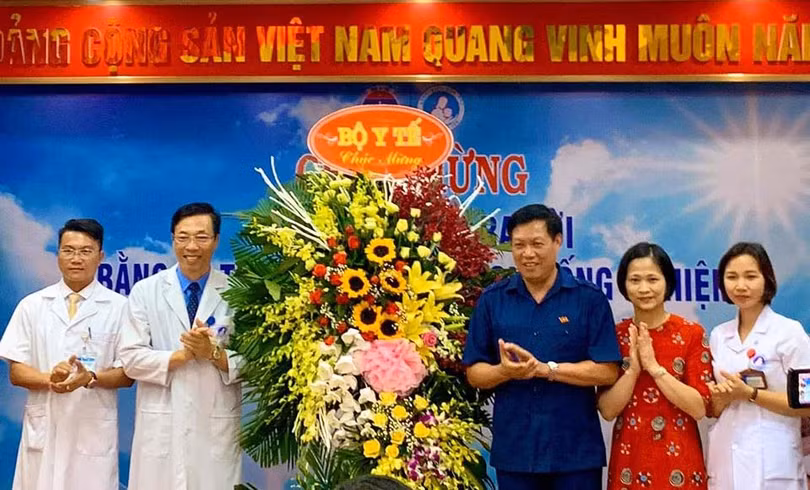 Thứ trưởng Bộ Y tế Đỗ Xuân Tuyên (áo xanh) chúc mừng em bé đầu tiên ra đời bằng kỹ thuật thụ tinh trong ống nghiệm. (Ảnh: Thảo Nguyên)