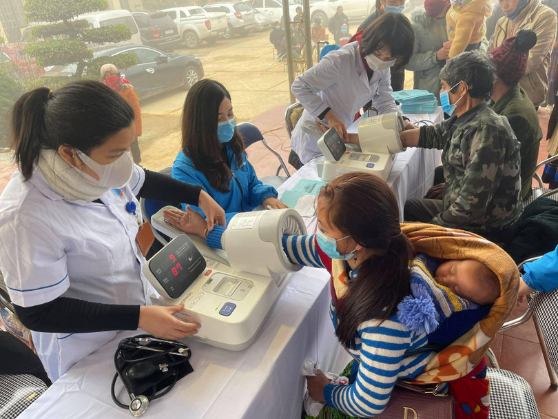 Nhân viên y tế đo huyết áp cho người dân (Ảnh: BVCC)