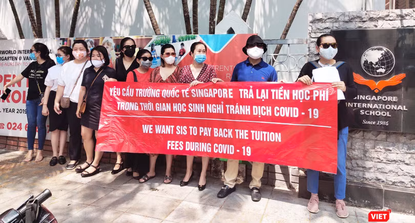 Phụ huynh đứng giữa trưa nóng đòi Trường Quốc tế Singapore trả tiền học phí. Ảnh: Minh Thúy 