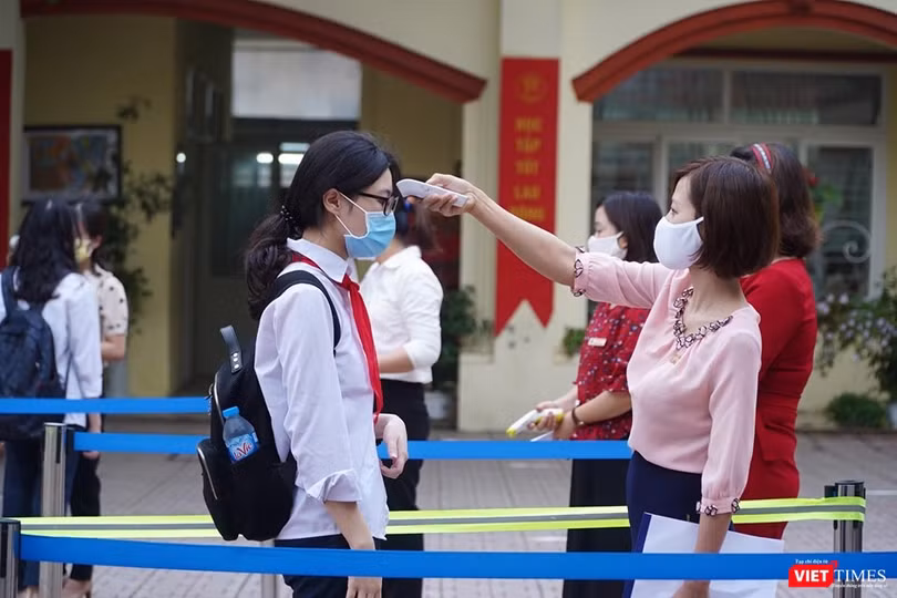 Giáo viên đo nhiệt độ cho học sinh (Ảnh - Minh Thuý) 