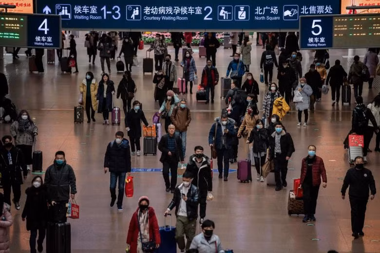 Người dân đeo mặt nạ khi đi du lịch vào dịp lễ năm mới tại nhà ga phía Tây Bắc Kinh, Trung Quốc. Ảnh: AFP