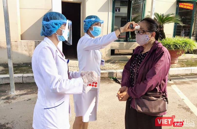 Nhân viên y tế đo nhiệt độ cho người dân (Ảnh: Minh Thuý) Nhân viên y tế đo nhiệt độ cho người dân (Ảnh: Minh Thuý)