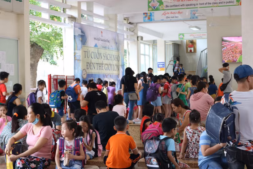 Học sinh tiểu học xếp hàng chờ nhận sách. (Ảnh: Minh Thúy)