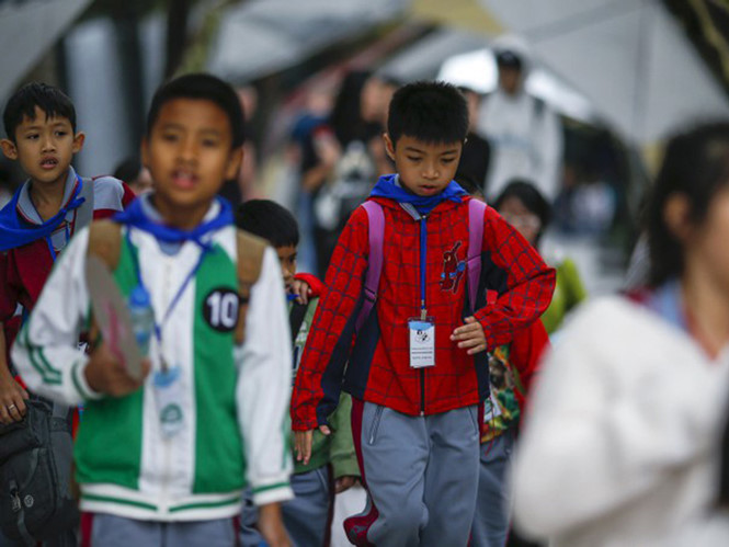 Học sinh mặc áo ấm trên đường phố Bangkok, Thái Lan ngày 25.1 - Ảnh: Reuters