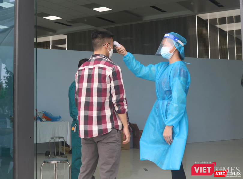 Kiểm tra nhiệt độ trước khi tiêm vaccine (Ảnh - Minh Thuý)