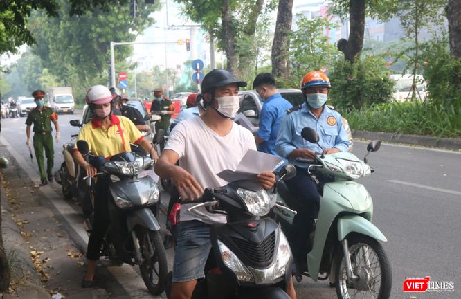 Người dân xếp hàng chờ kiểm tra giấy đi đường (Ảnh - Minh Thuý) 