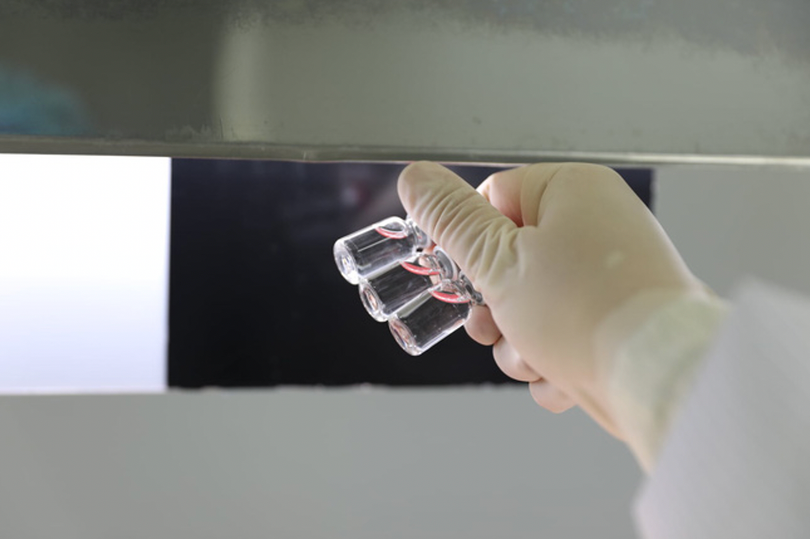 Vaccine sau đó được chuyển đến bàn soi, nhằm kiểm tra dị vật trong lọ