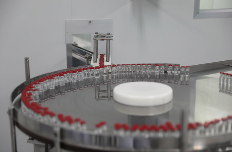 Sau khi được soi kĩ lưỡng, các lọ vaccine được chuyển sang bàn xoay dán nhãn