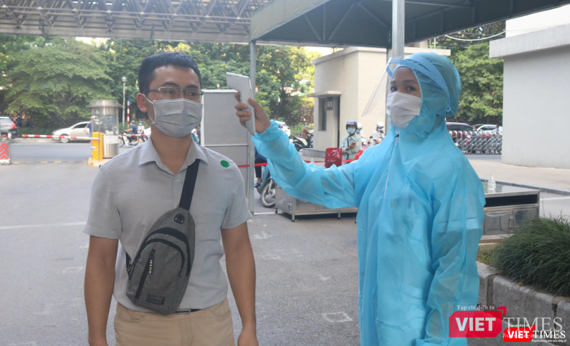 Nhân viên y tế đo nhiệt độ của người dân (Ảnh - Minh Thuý)