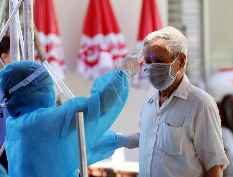 Nhân viên y tế đo nhiệt độ cho người dân (Ảnh: BYT)