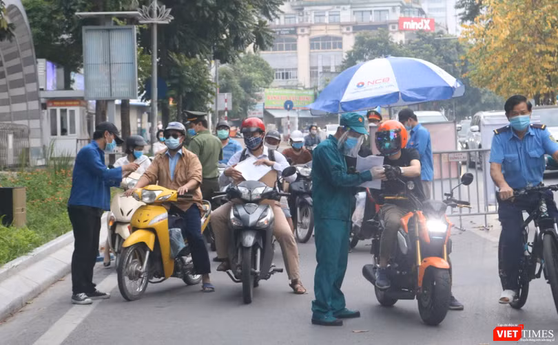Người dân xuất trình giấy tờ chờ qua chốt kiểm soát phòng dịch COVID-19 (Ảnh - Minh Thuý) 