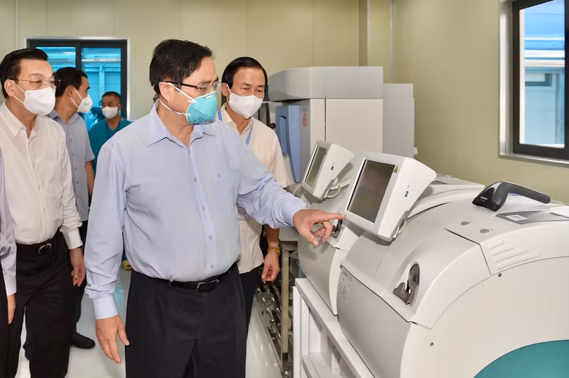 Thủ tướng Phạm Minh Chính kiểm tra hệ thống máy xét nghiệm COVID-19 tại phòng Lab của bệnh viện.