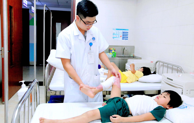 Kỹ thuật viên hướng dẫn bệnh nhi bị bỏng phục hồi chức năng. Ảnh: Trung tâm Sản nhi, Bệnh viện Đa khoa tỉnh Phú Thọ 