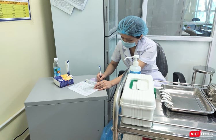Bác sĩ ghi nhật ký tiêm chủng (Ảnh: Minh Thúy)