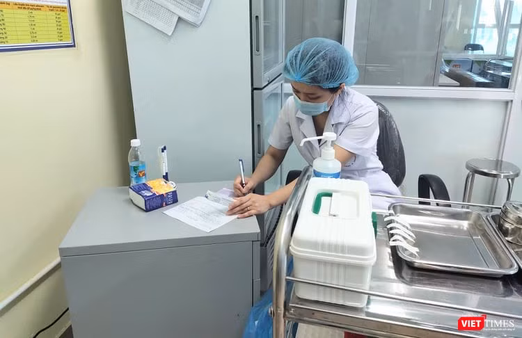 Bác sĩ ghi nhật ký tiêm chủng (Ảnh: Minh Thúy)