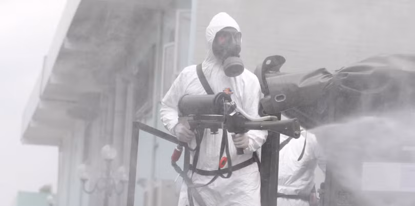 Nhân viên y tế phun khử khuẩn phòng COVID-19 (Ảnh - Hoàng Anh)