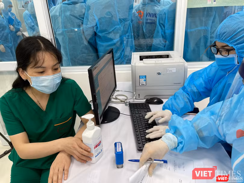 Nhân viên y tế kiểm tra hồ sơ trước khi tiêm vaccine (Ảnh - Tuấn Dũng)