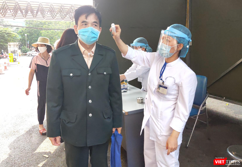 Nhân viên y tế đo nhiệt độ cho người dân (Ảnh - Minh Thuý) 