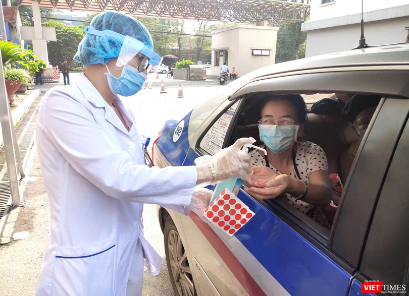 Nhân viên y tế yêu cầu người dân rửa tay trước khi vào bệnh viện (Ảnh - Minh Thuý) 