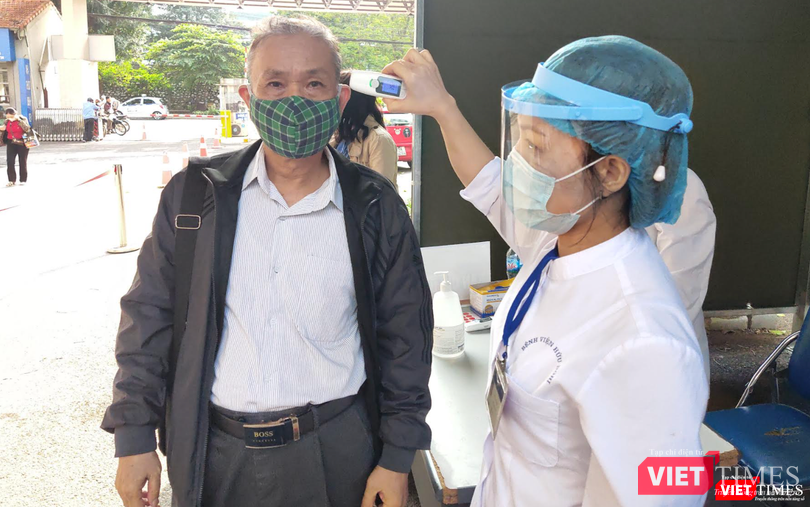 Nhân viên y tế kiểm tra nhiệt độ cho người dân (Ảnh - Minh Thuý)